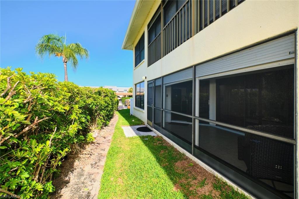 Ground-level screened patio featuring multiple sliding glass doors with roll-down storm shutters