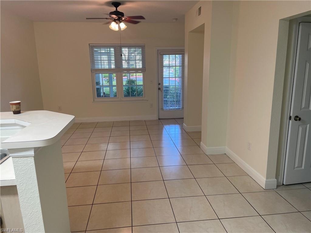 Unfurnished dining area with light tile patterned floors and a ceiling fan
