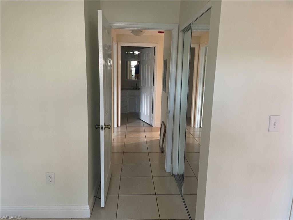 Hallway featuring baseboards and light tile patterned flooring