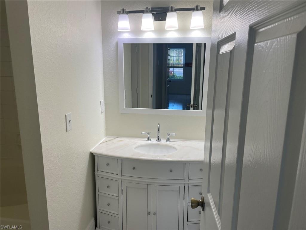 Bathroom with vanity and a textured wall
