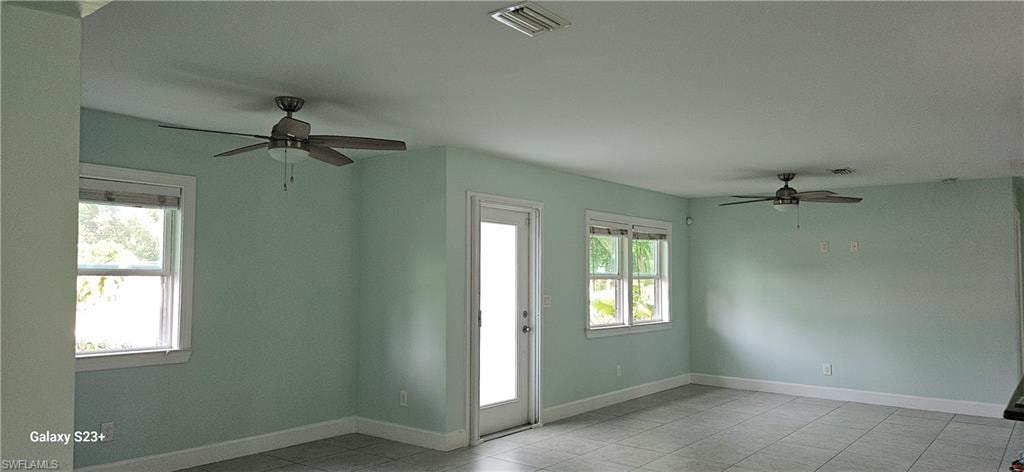 Spare room featuring ceiling fan and light tile patterned flooring