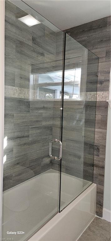 Full bathroom featuring shower / bath combination with glass door