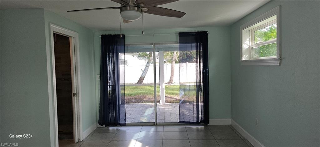 Doorway to outside featuring tile patterned flooring and ceiling fan