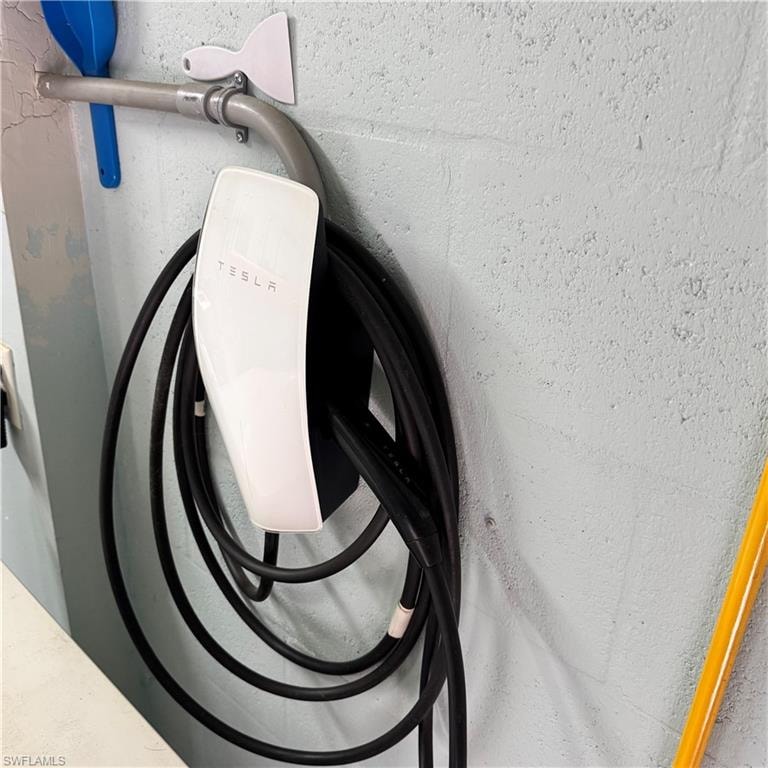 Wall-mounted electric vehicle charging station with integrated cable management