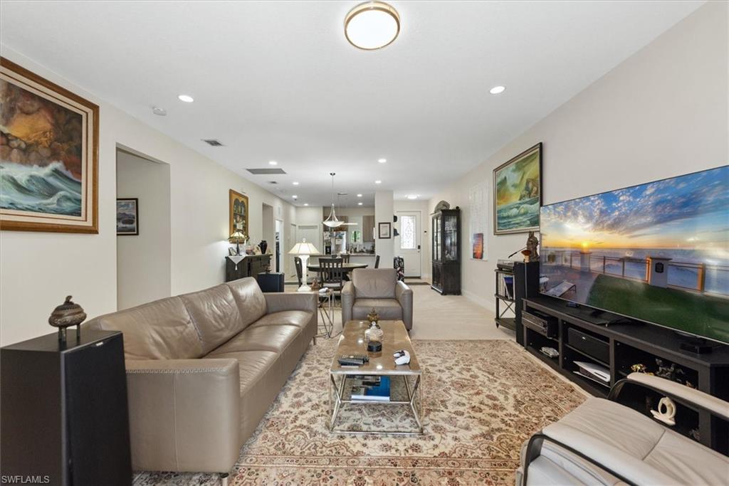 Spacious living area featuring light-toned walls, recessed lighting, and a neutral-toned ceiling