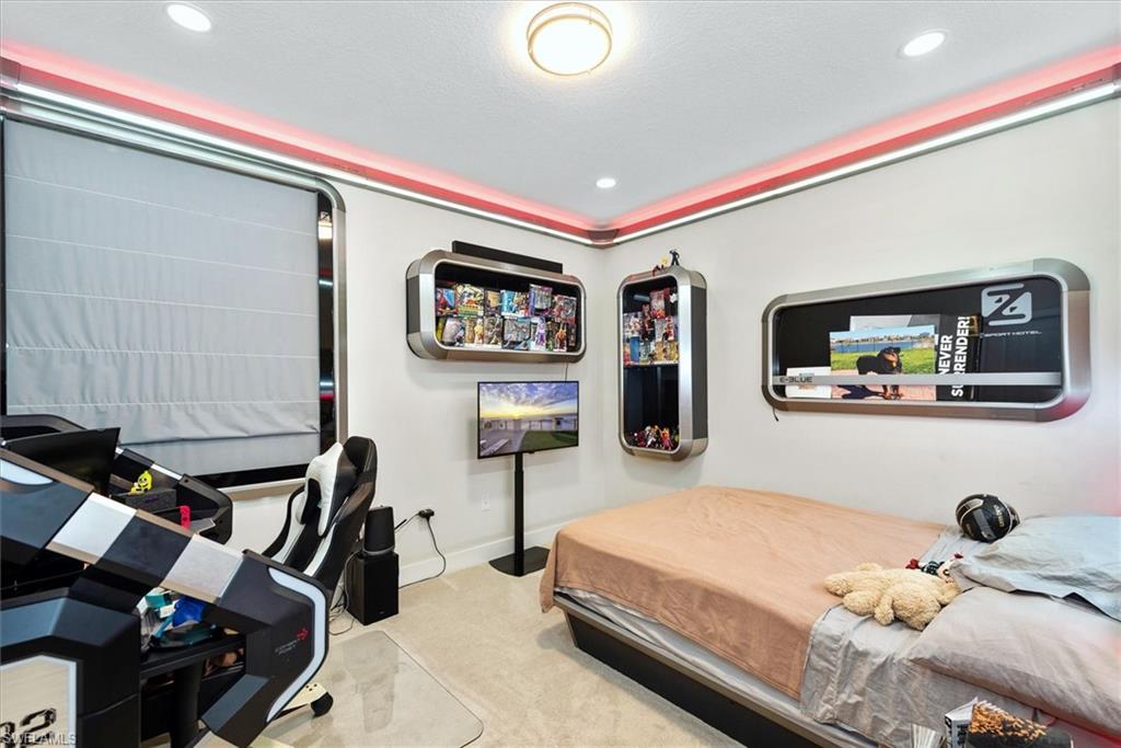 Room featuring wall-mounted shelving, recessed lighting, and a window with a Roman shade