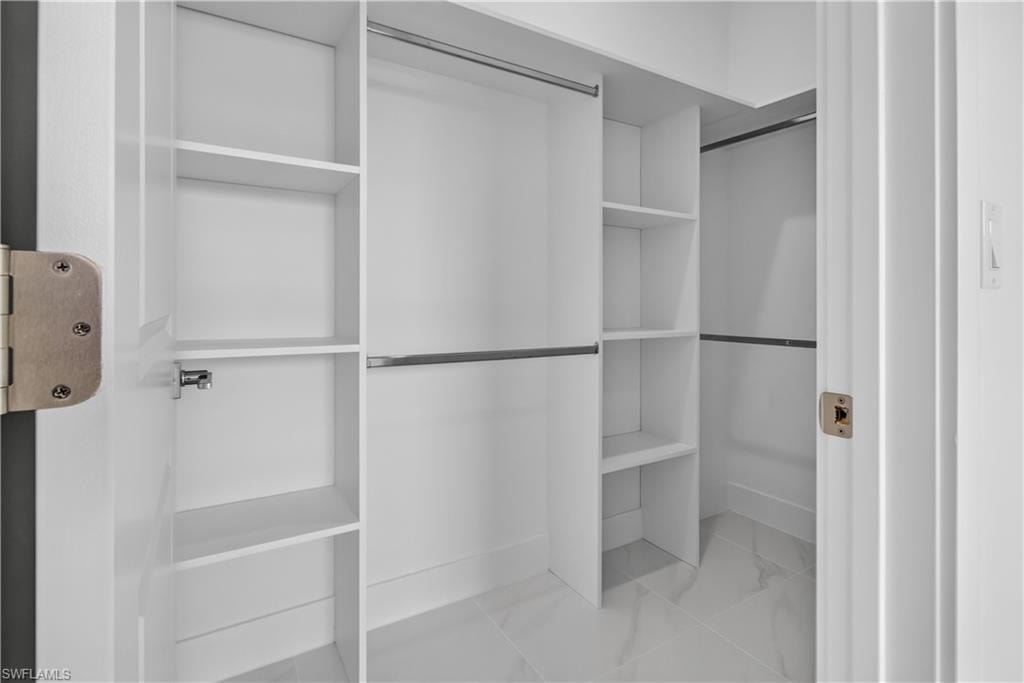 White closet system with multiple shelving units and hanging rods
