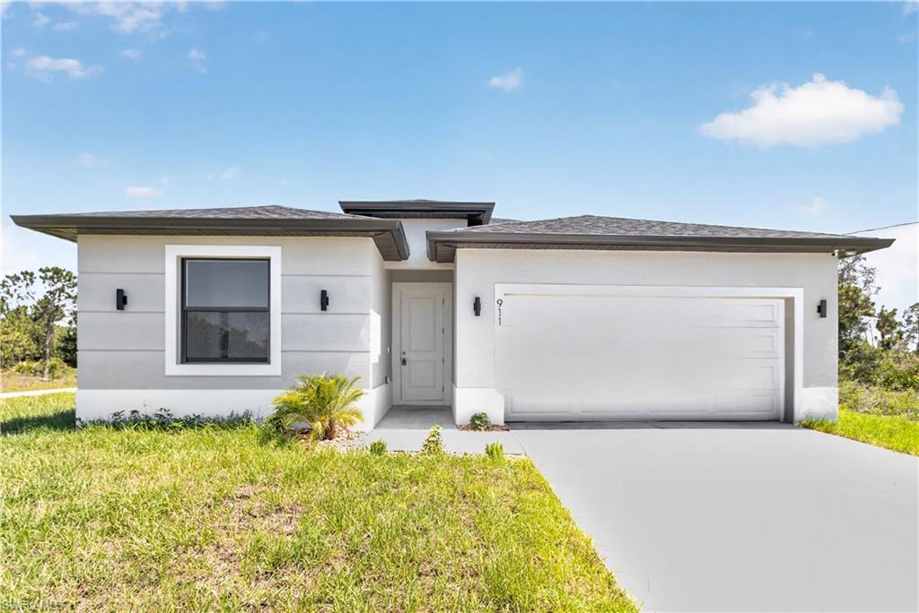 Modern stucco exterior featuring a white garage door, dark framed windows, and exterior wall sconces