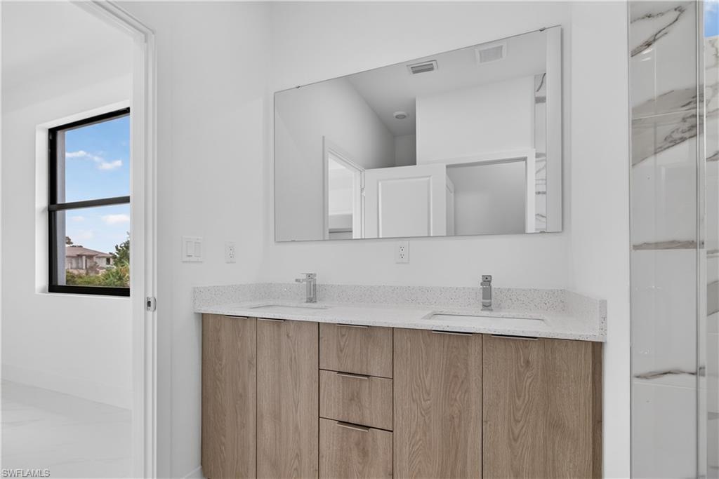 Dual vanity with wood-finish cabinetry and light-colored countertops
