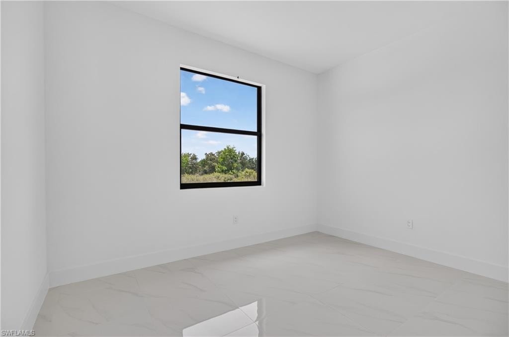 Bright interior space featuring a large window with black framing, offering exterior scenery