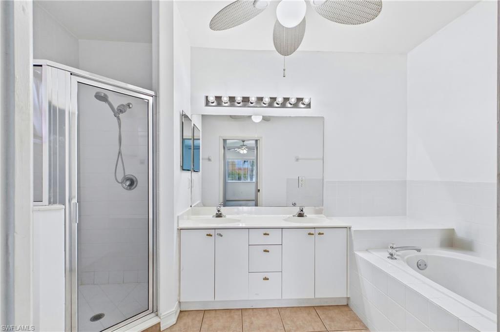 Relax in the luxurious en-suite bathroom featuring both a soaking tub and separate glass-enclosed shower.