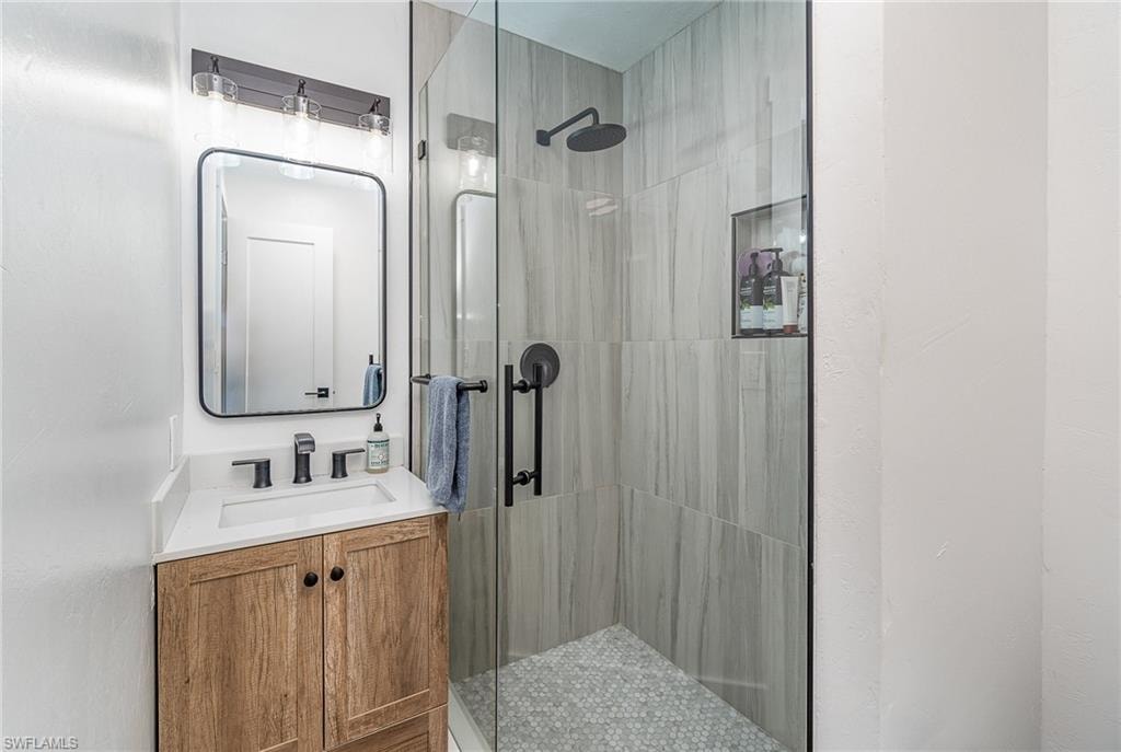 Contemporary bathroom featuring a glass-enclosed shower with gray tile walls and a hexagonal tile floor