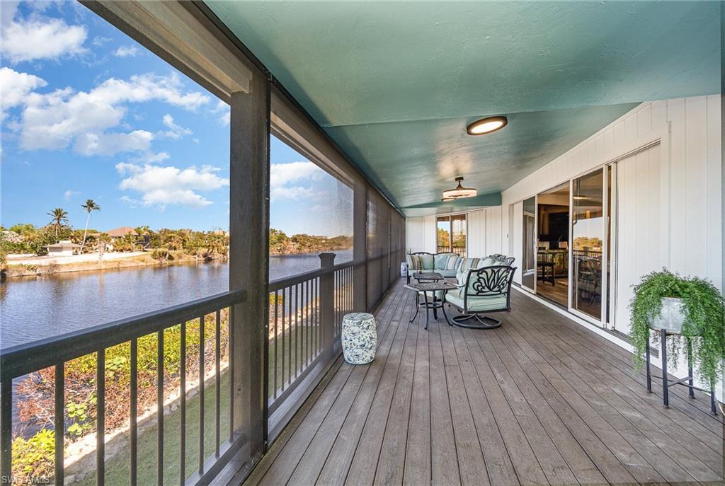 Screened balcony featuring wood-finish decking and direct waterway frontage