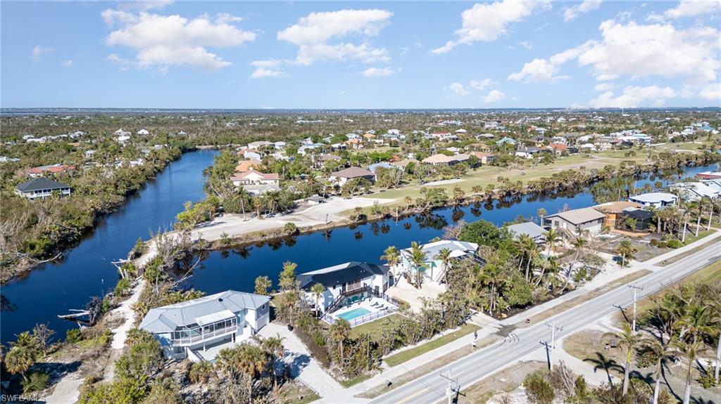 Aerial perspective showcasing waterfront properties along a canal with mature trees