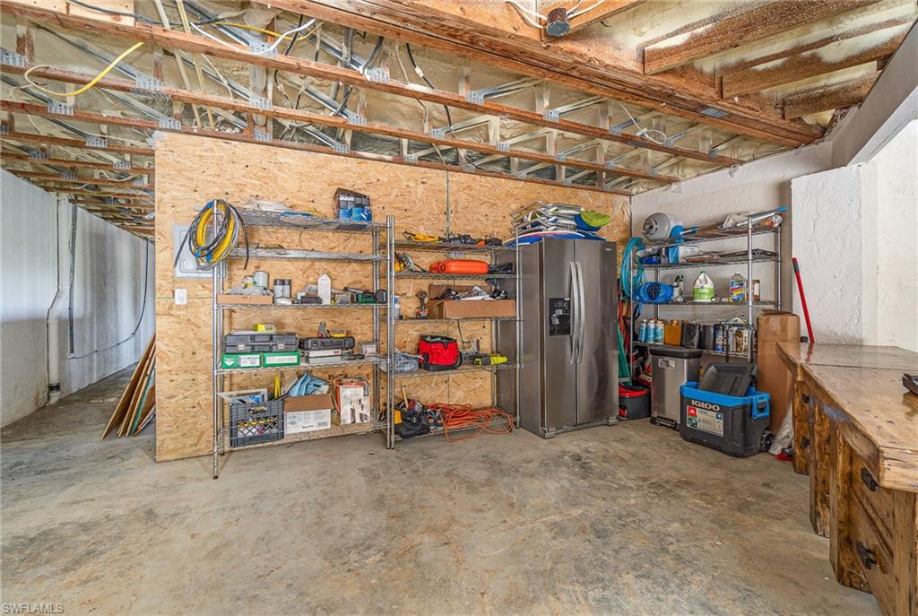 Concrete flooring with exposed ceiling joists and visible insulation