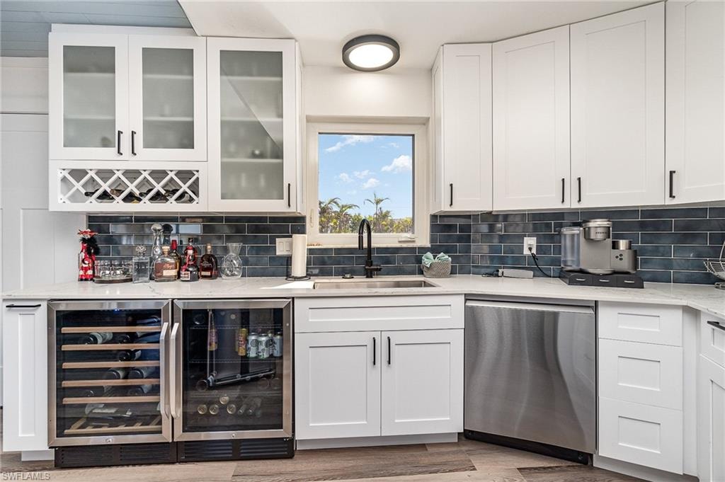 Contemporary kitchen featuring white cabinetry, a blue subway tile backsplash, and quartz countertops