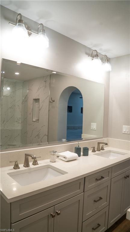 Dual vanity with integrated sinks, brushed nickel fixtures, light-toned countertop, and light gray cabinetry