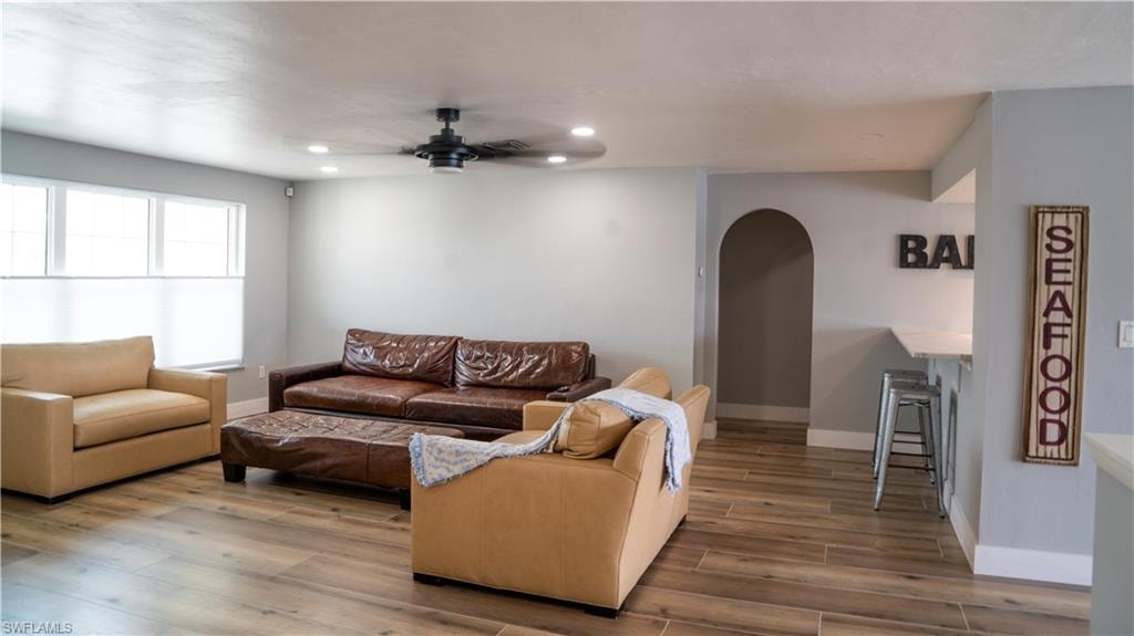Spacious living area featuring wood-finish flooring, recessed lighting, and a modern ceiling fan