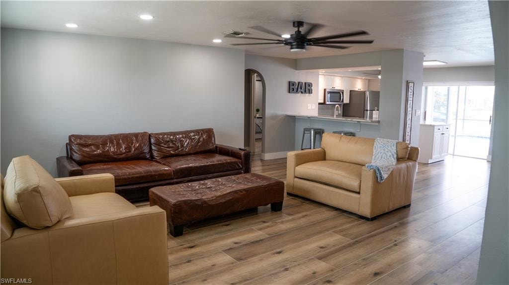 Open-concept living area featuring wood-finish flooring, recessed lighting, and a contemporary ceiling fan