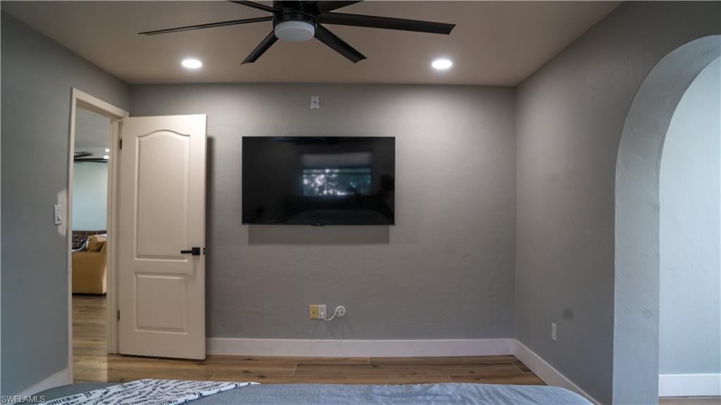 Room featuring wood-finish flooring, recessed lighting, and a ceiling fan