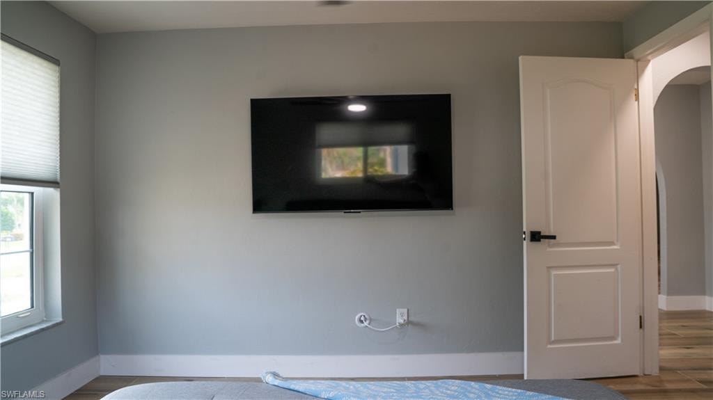 Interior room featuring light gray walls, white trim, and a wall-mounted display