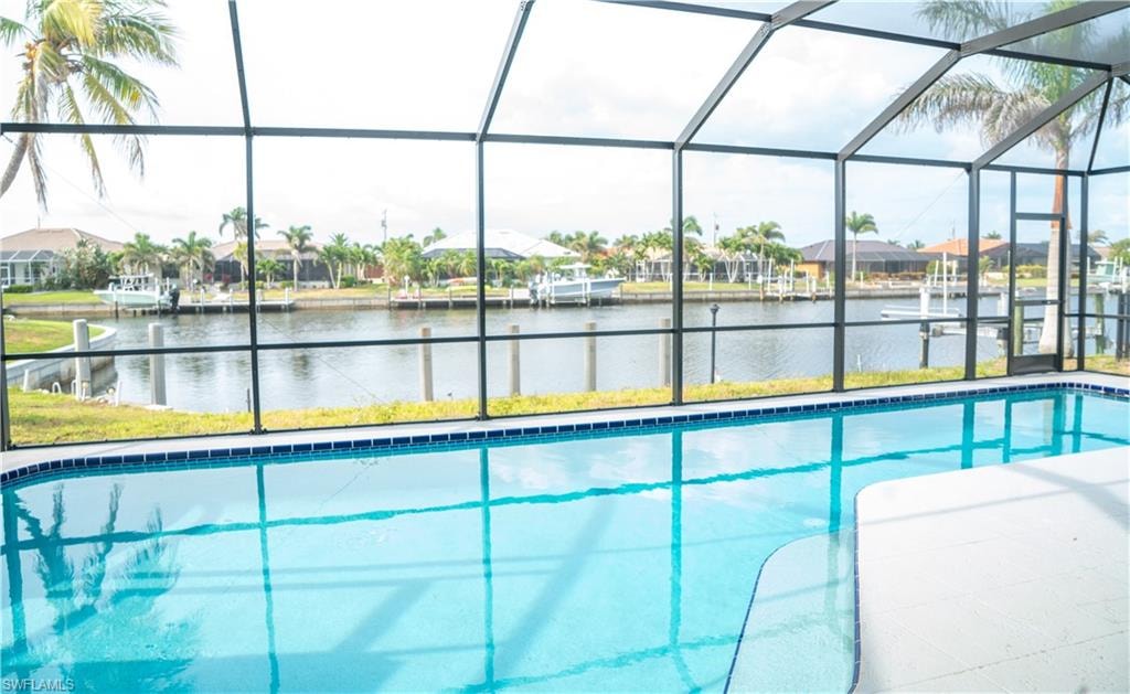 Screened lanai featuring a swimming pool with light blue water and a tiled edge