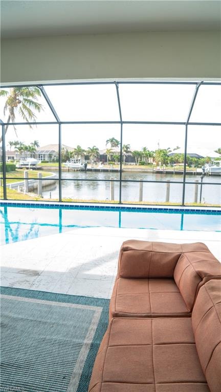 Screened outdoor living area featuring a pool, canal frontage, and a concrete patio