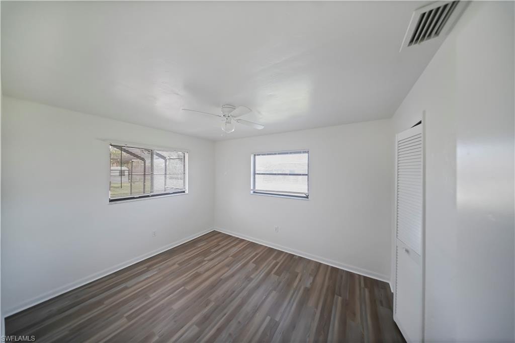 Bright interior space featuring wood-finish flooring, white walls, and a ceiling fan
