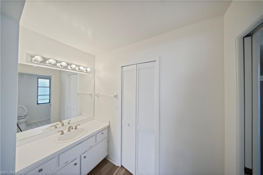 Bathroom vanity with an integrated sink, brushed nickel faucet, and a large mirror with a six-light fixture