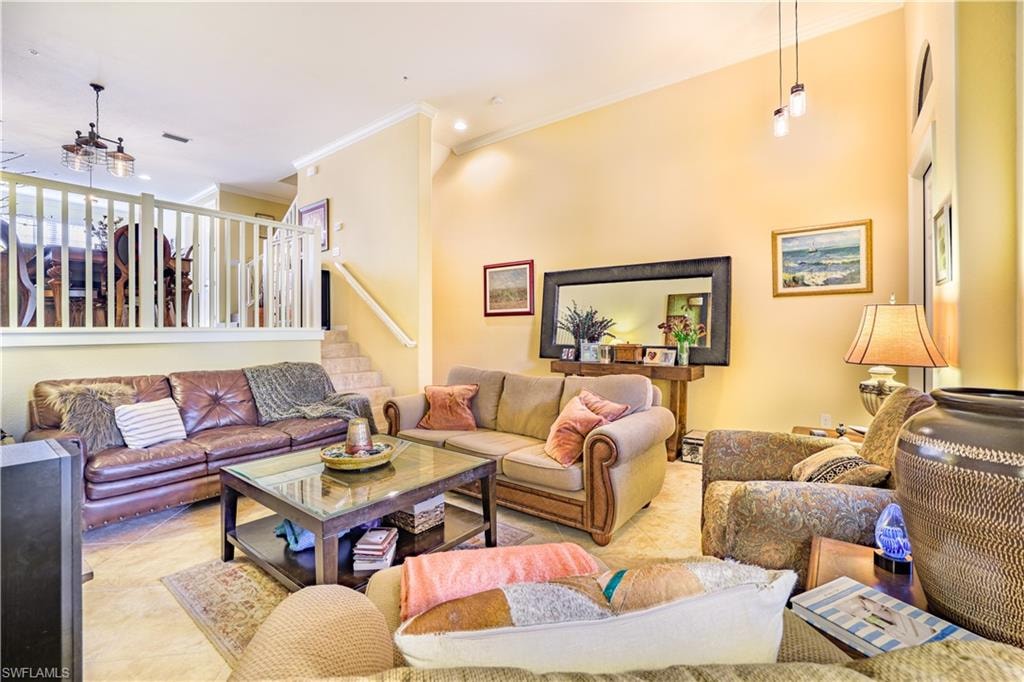 Spacious living area featuring high ceilings, light-toned wall finishes, and tile flooring