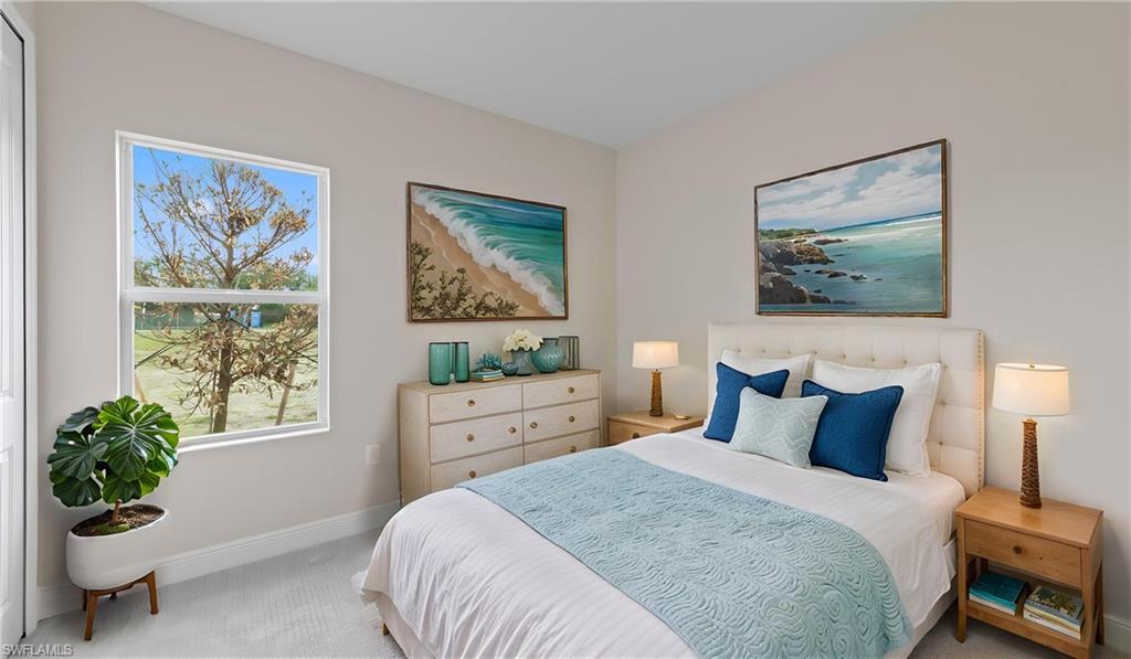 A second carpeted guest bedroom in calming tones with coastal-style artwork, a comfortable layout, and garden views.