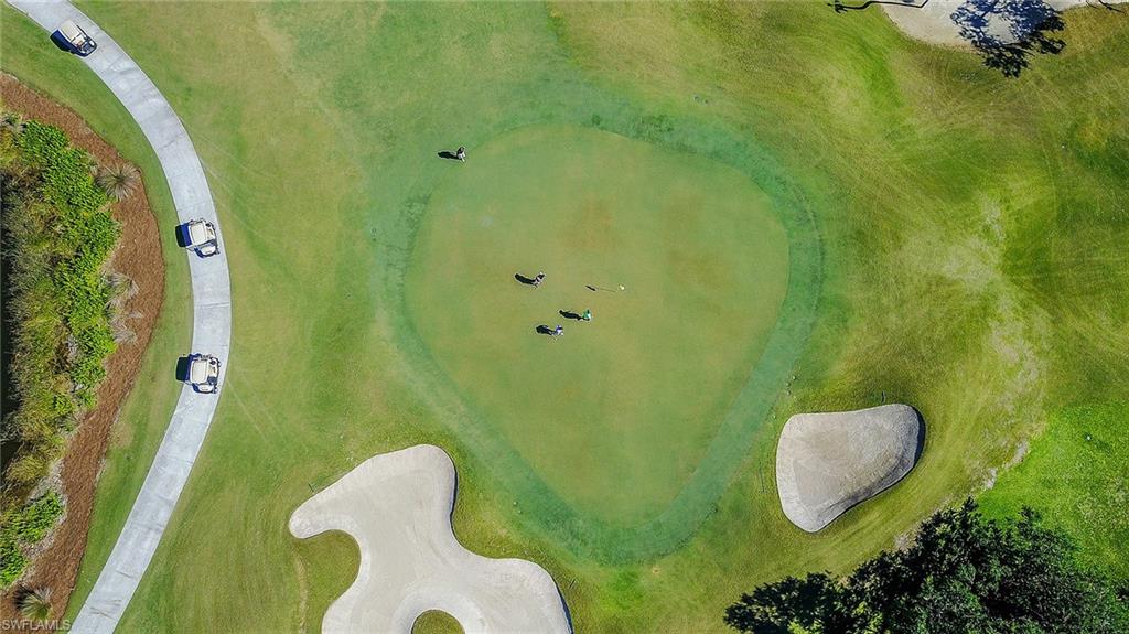 Aerial view of a manicured green and sand bunkers on the community's golf course.
