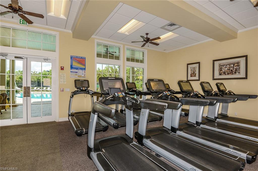 The attended fitness center offers rows of cardio equipment and bright views toward the pool.