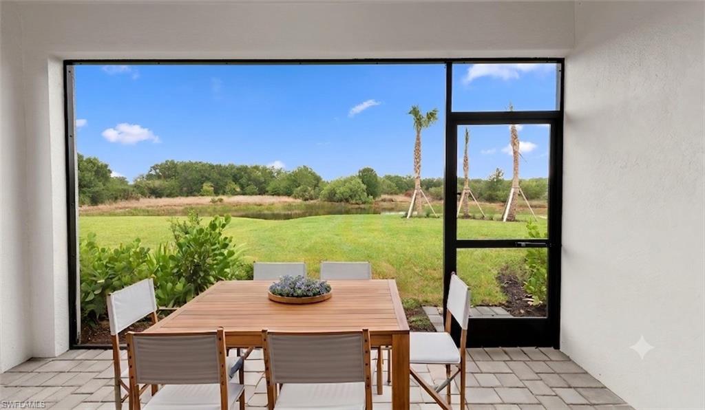 Screened-lanai dining opens to peaceful preserve and open green-space views over Slate pavers, ideal for relaxed, year-round Florida living.