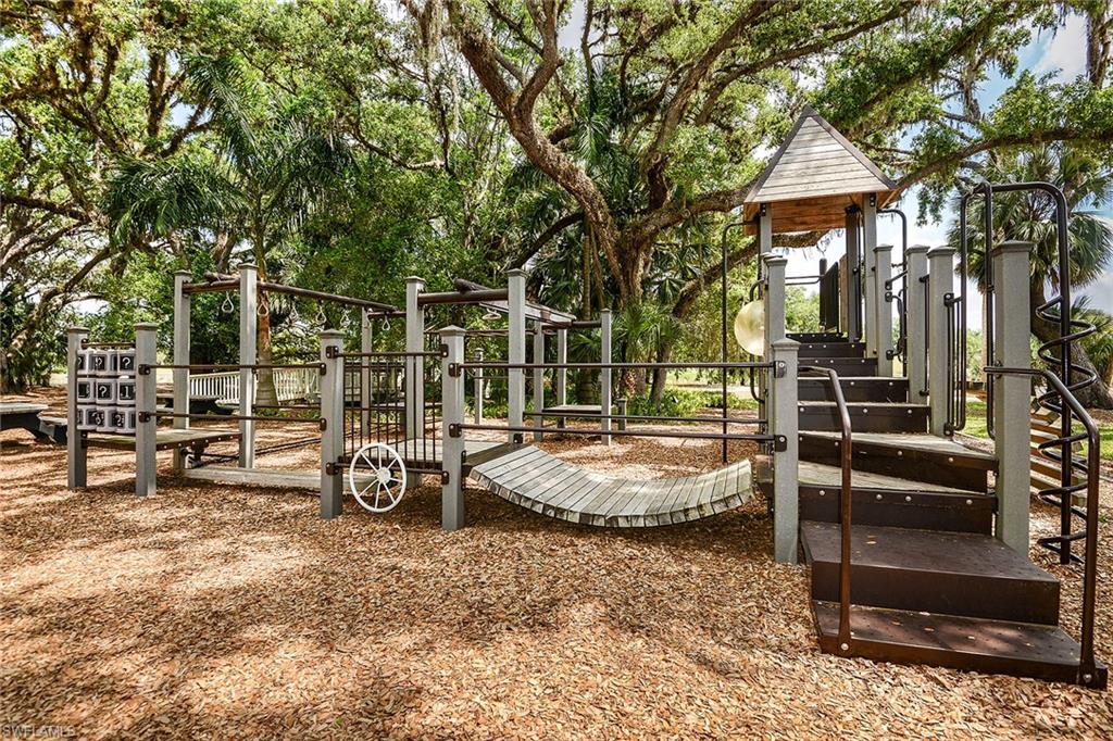 A shaded community playground tucked beneath grand oak trees.