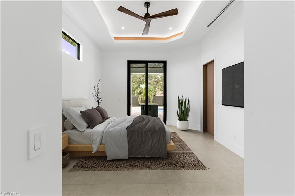Bright interior space featuring a tray ceiling with recessed lighting and a ceiling fan