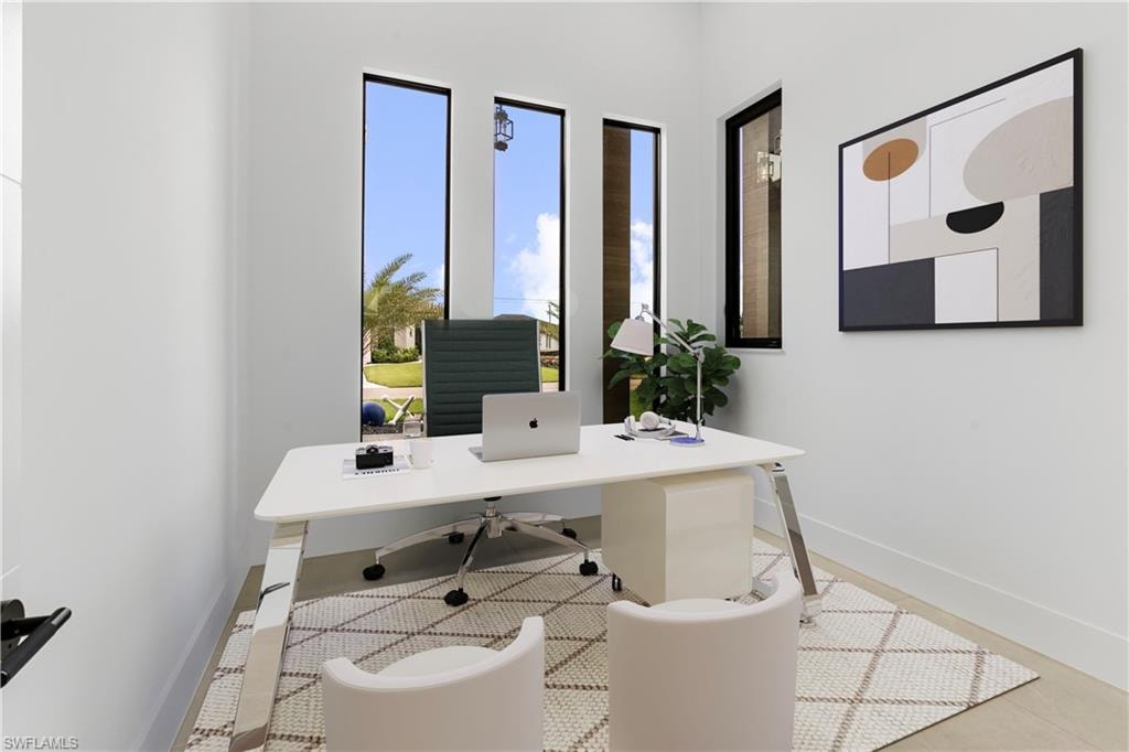 Office space featuring three tall vertical windows with black frames, offering abundant natural light