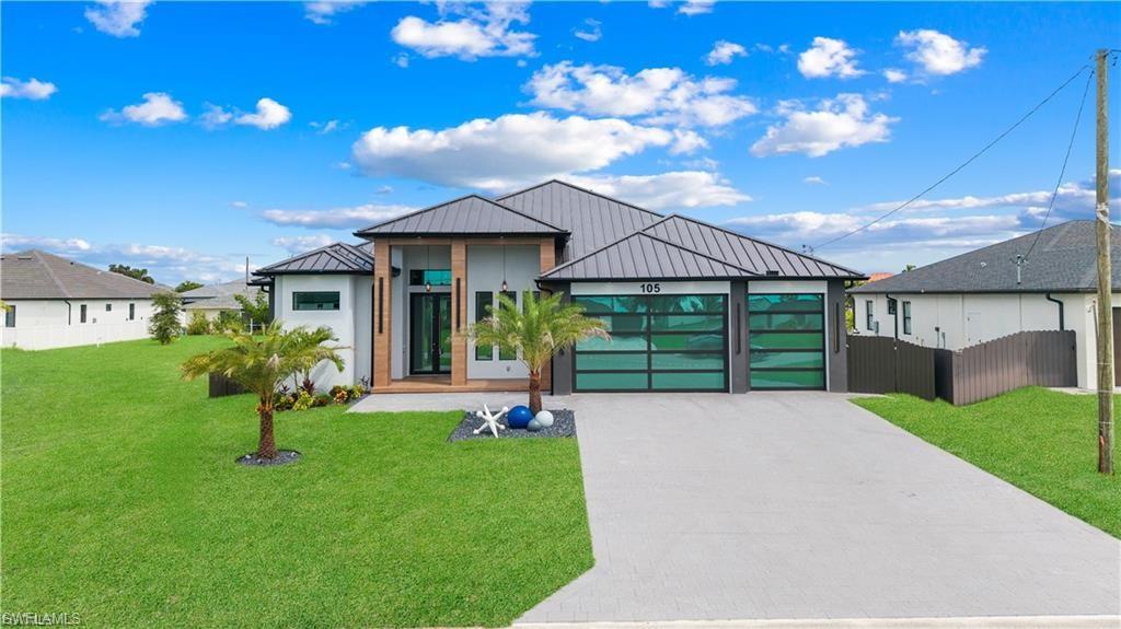Contemporary exterior with a metal roof, two-car garage with frosted glass doors, and a concrete driveway