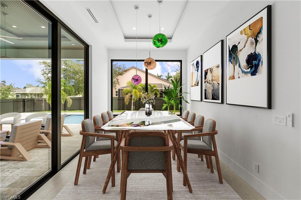 Dining area featuring a recessed ceiling, large framed window, and sliding glass doors