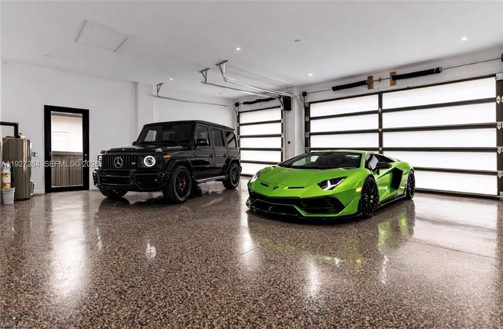 Spacious garage featuring polished speckled concrete flooring, white walls, and two modern sectional garage doors