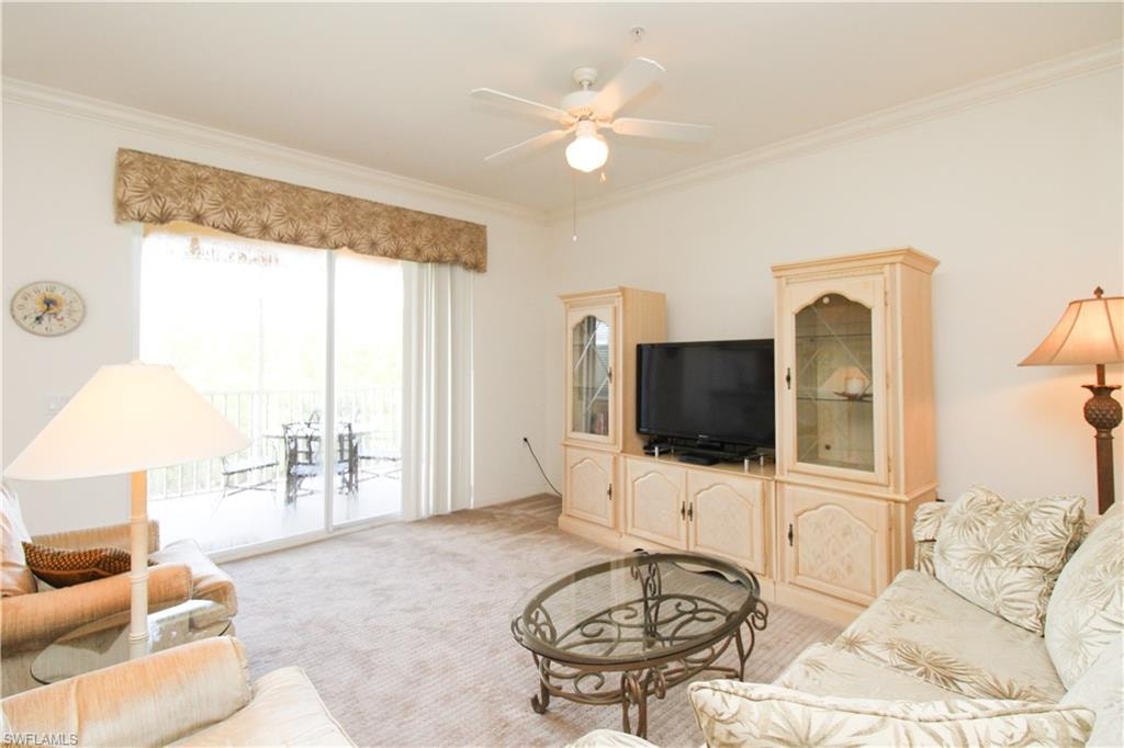 Living room featuring crown molding, light colored carpet, and ceiling fan