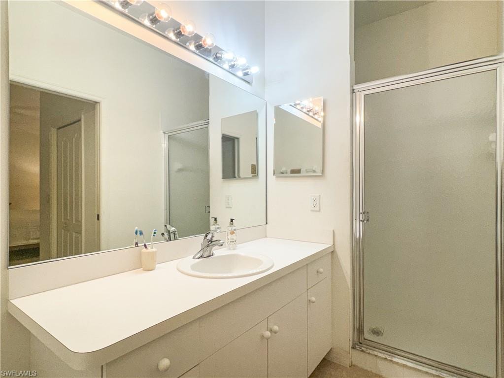 Bathroom featuring vanity and a shower with shower door