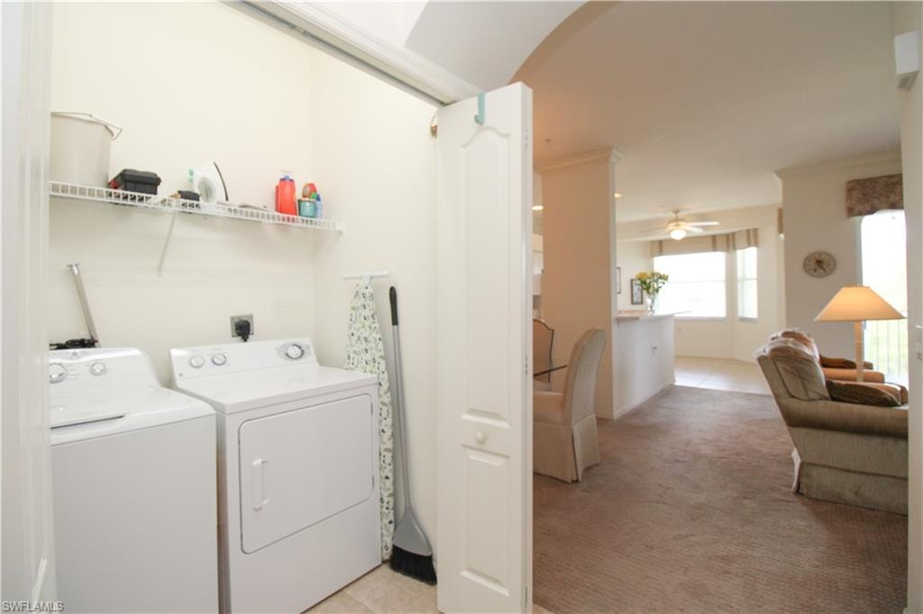 Laundry area with washer and clothes dryer, ceiling fan, and light colored carpet