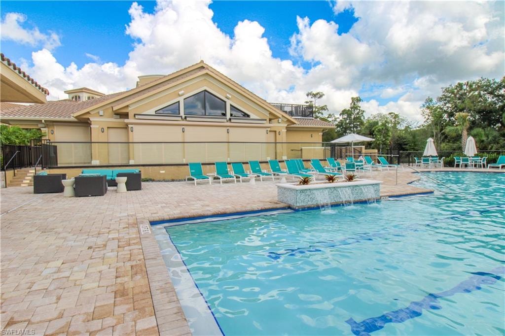 View of swimming pool featuring an outdoor living space, a patio area, and pool water feature