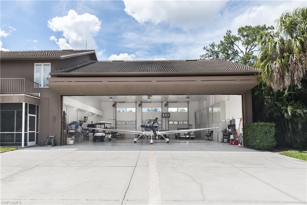 HANGAR OPENING 42' BIFOLD DOOR 11.6'H. View from rear of home showing the hangar right on the Taxiway. Plenty of cabinetry for storing tools etc.