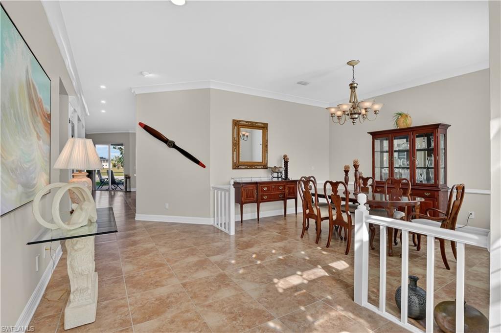 Dining area with crown molding, recessed lighting, a chandelier, and light tile patterned floors