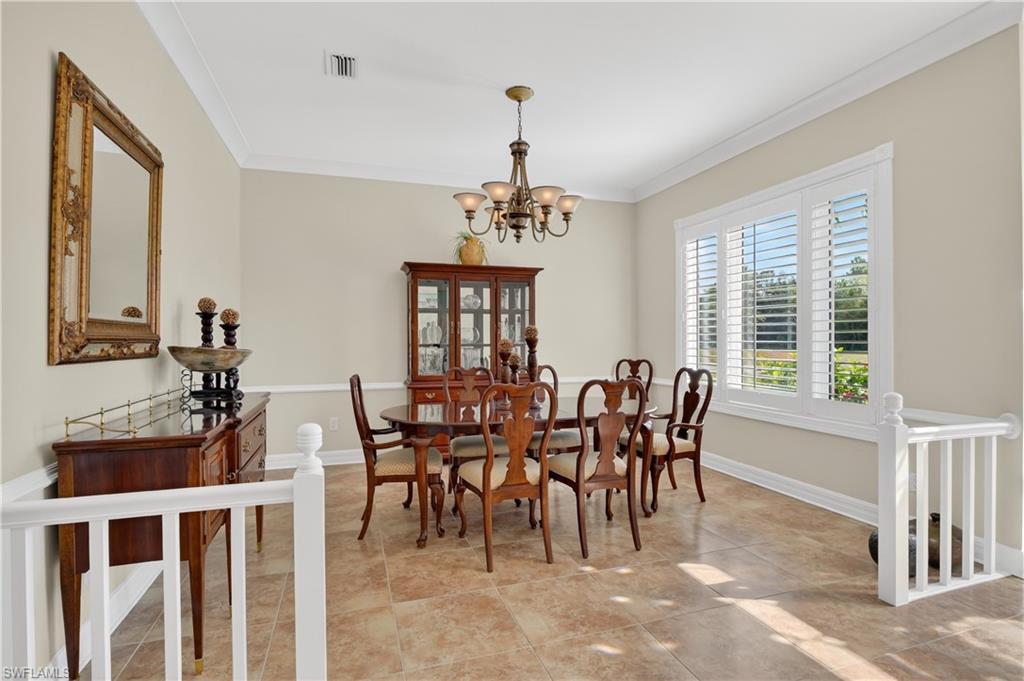 Dining space with ornamental molding and a chandelier