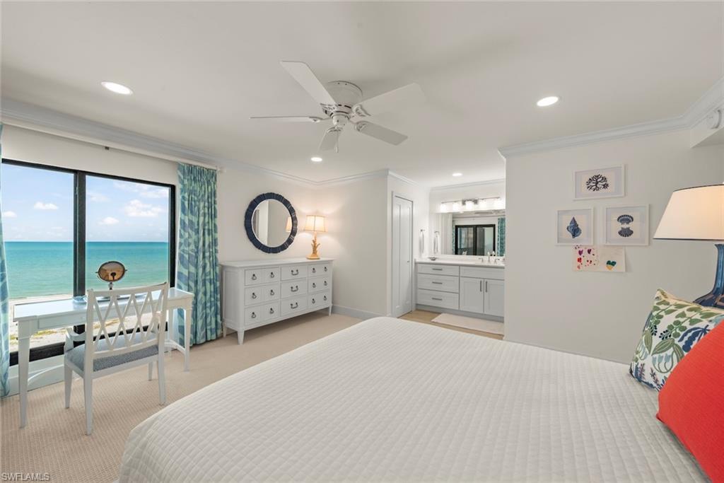 Expansive window framing ocean views, recessed lighting, crown molding, ceiling fan, and an integrated vanity area with double sinks