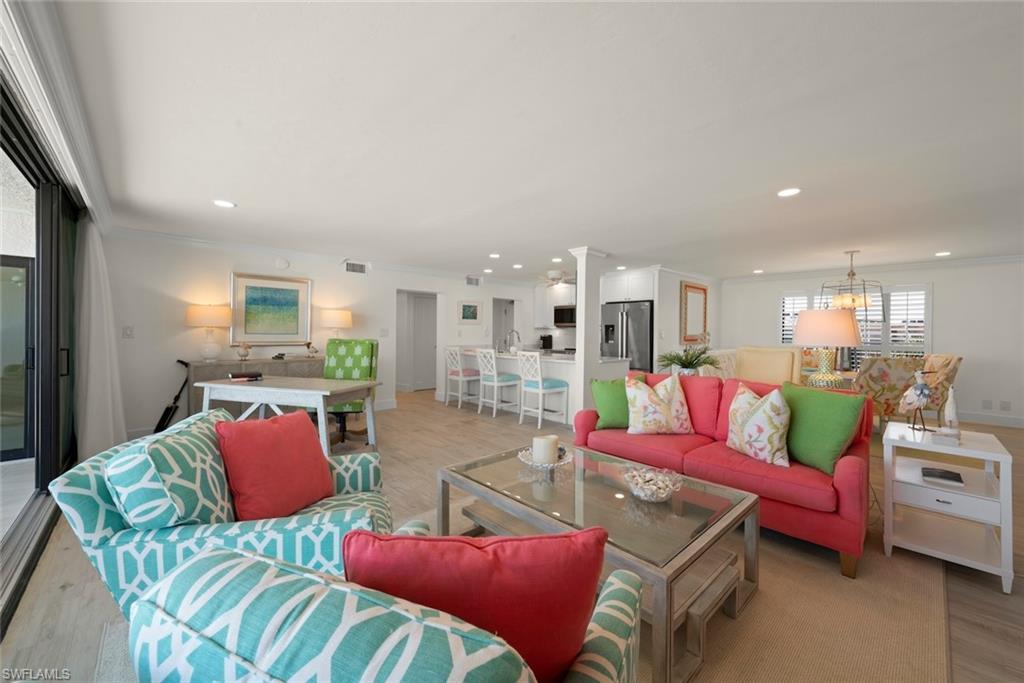 Open-concept living area with light-toned flooring and recessed lighting