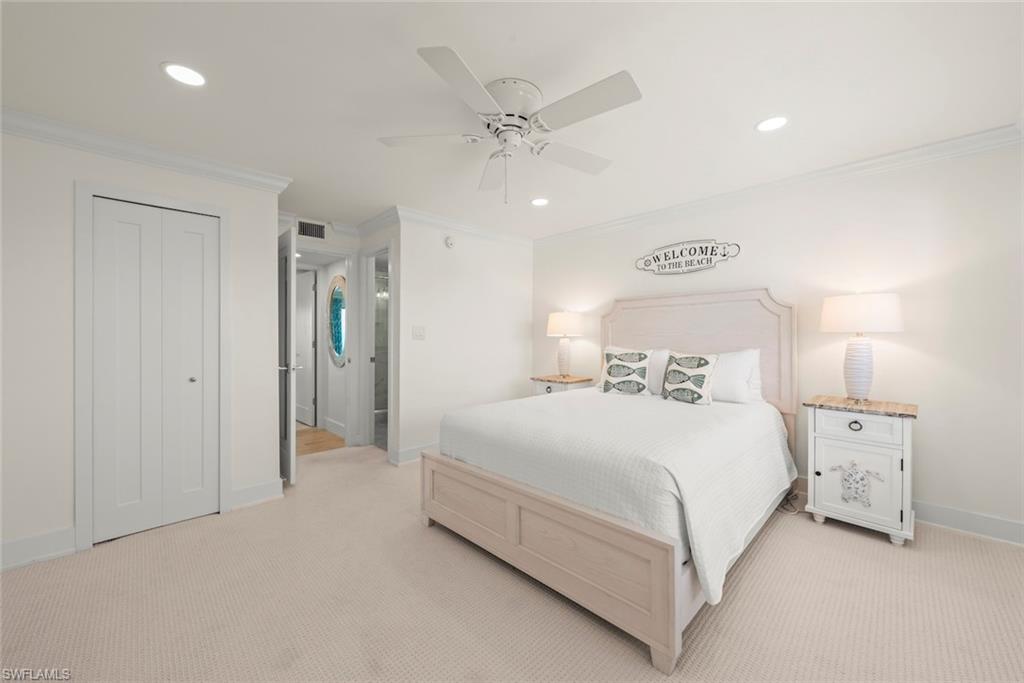 Carpeted bedroom featuring a ceiling fan, recessed lighting, crown molding, and bifold closet doors